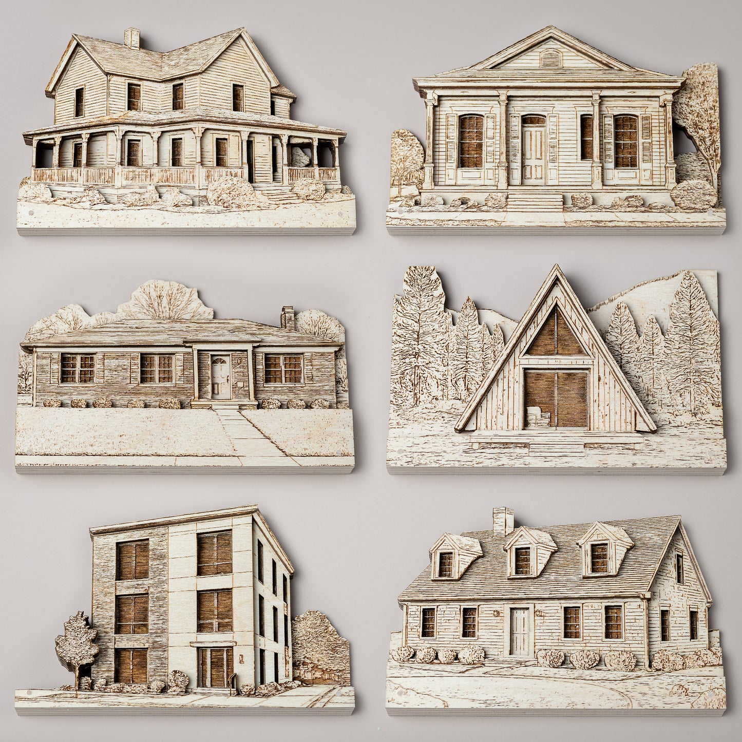 Set of six miniature house models on a gray background