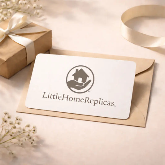 Gift card with 'LittleHomeReplicas' logo on a beige envelope with a gift box and ribbons in the background.