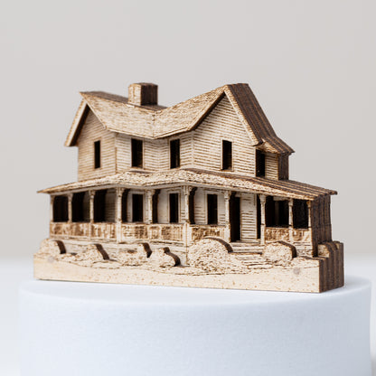 Wooden model of a house angled to show its layering on a white background