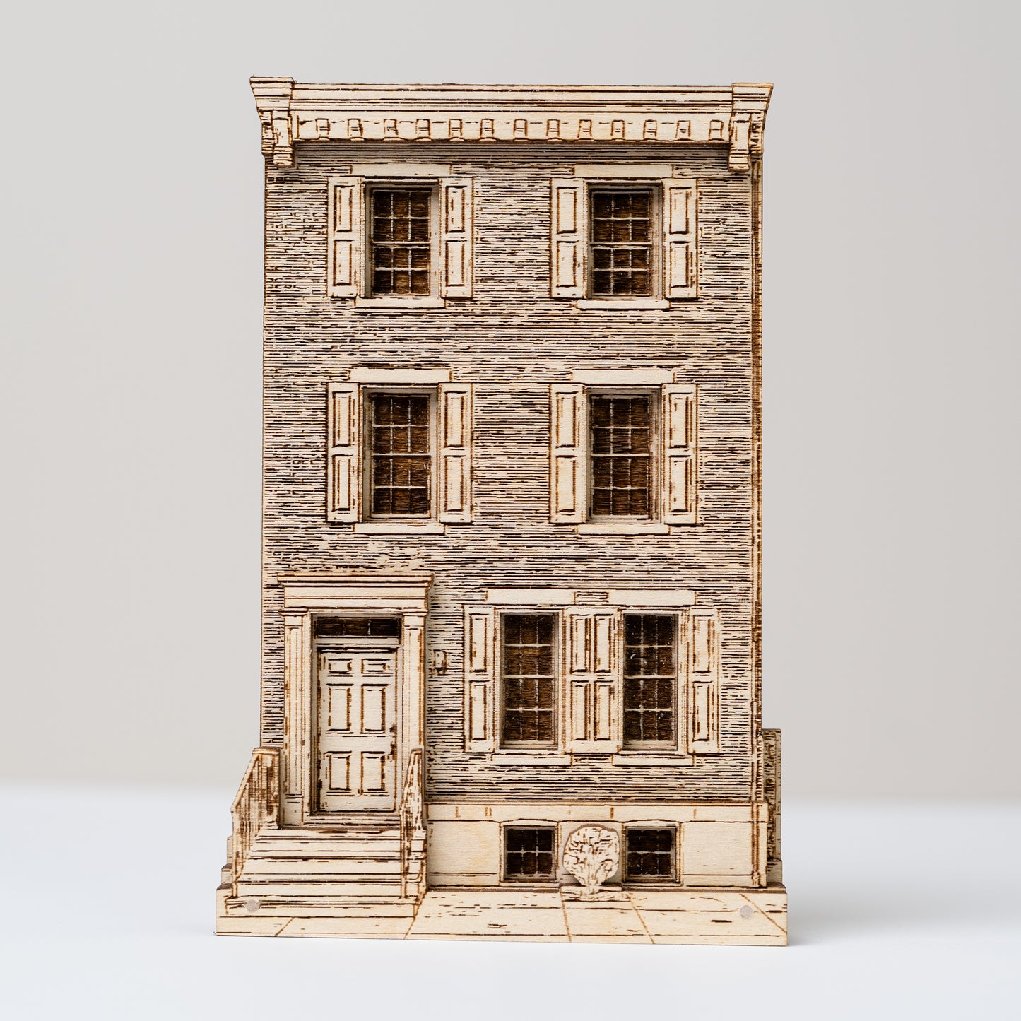 Model of a multi-story building with wooden facade and shutters on a white background