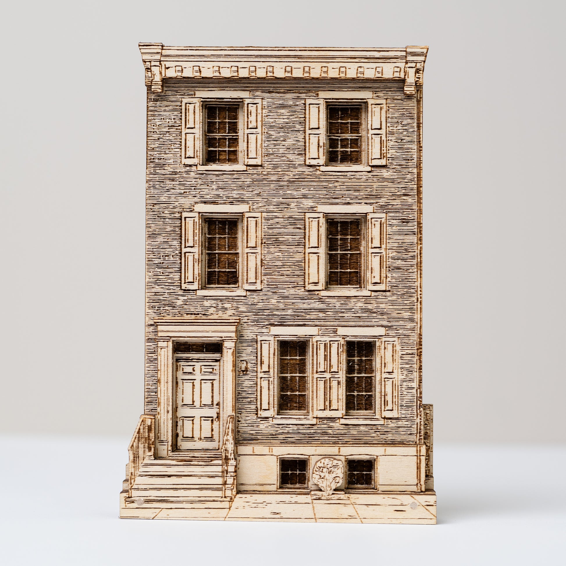 Model of a multi-story building with wooden facade and shutters on a white background