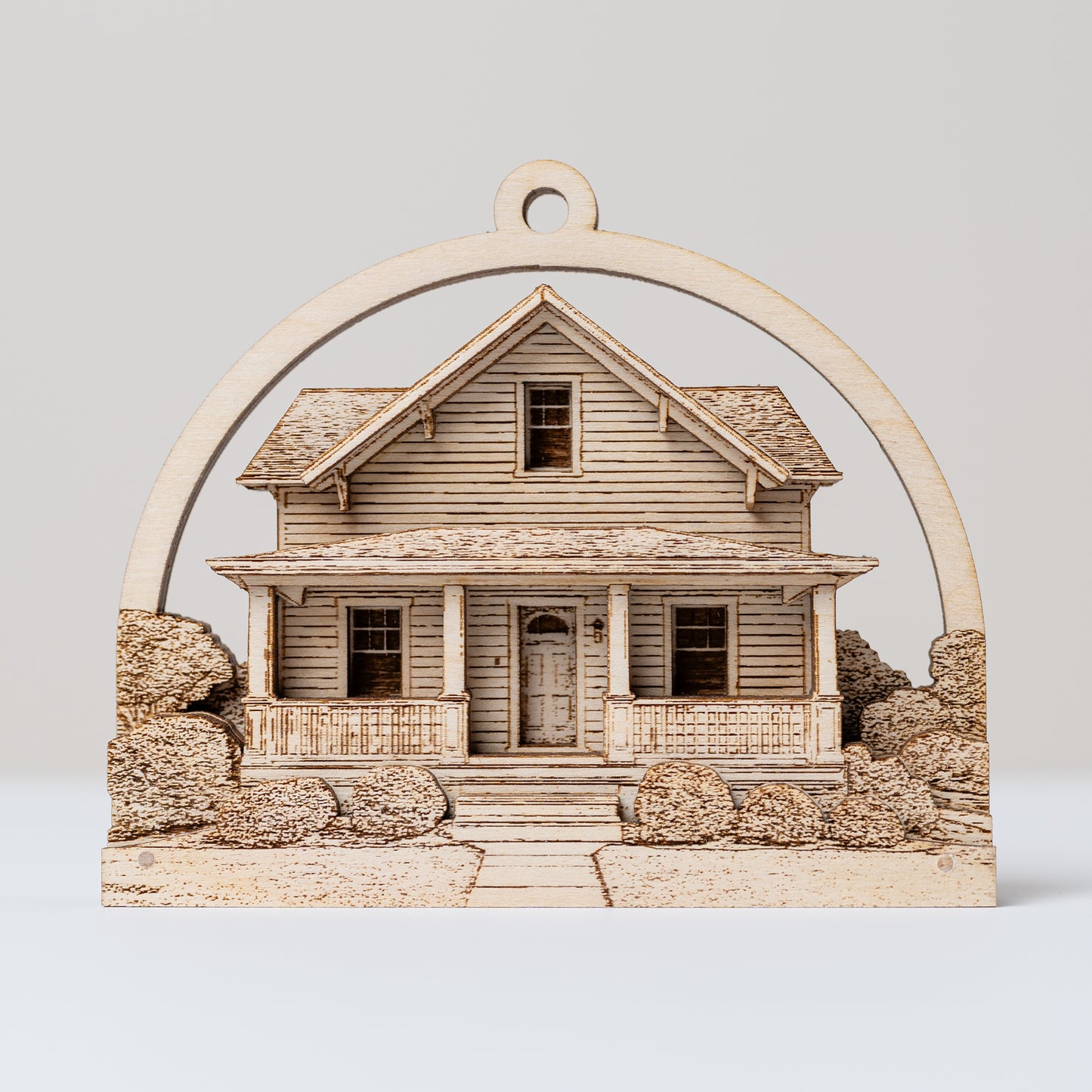 Wooden house model ornament with a decorative arch on a light gray background