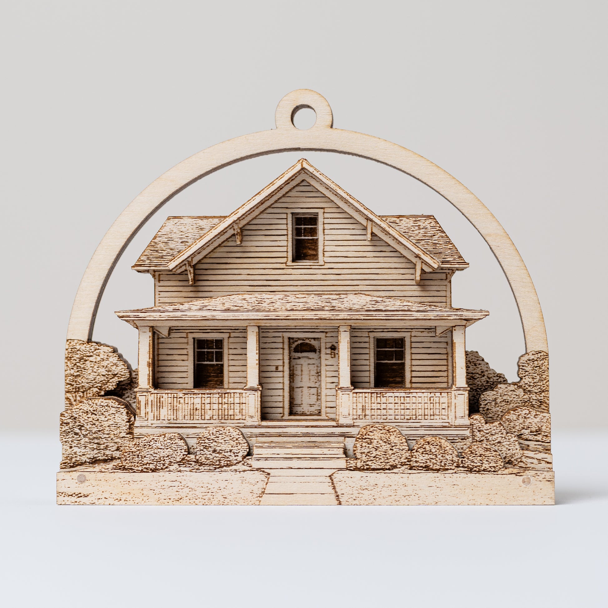 Wooden house model ornament with a decorative arch on a light gray background